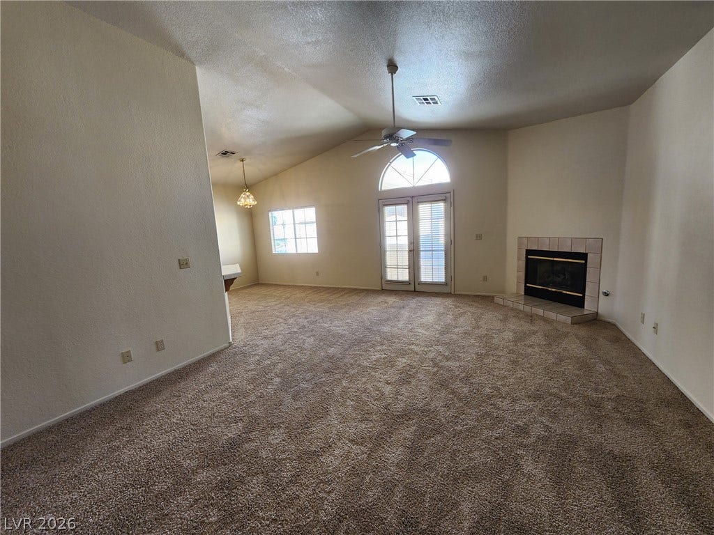 8301 Boseck Drive, #237, Las Vegas, NV 89145 A spacious living area features vaulted ceilings, plush carpeting, and a classic tiled fireplace.