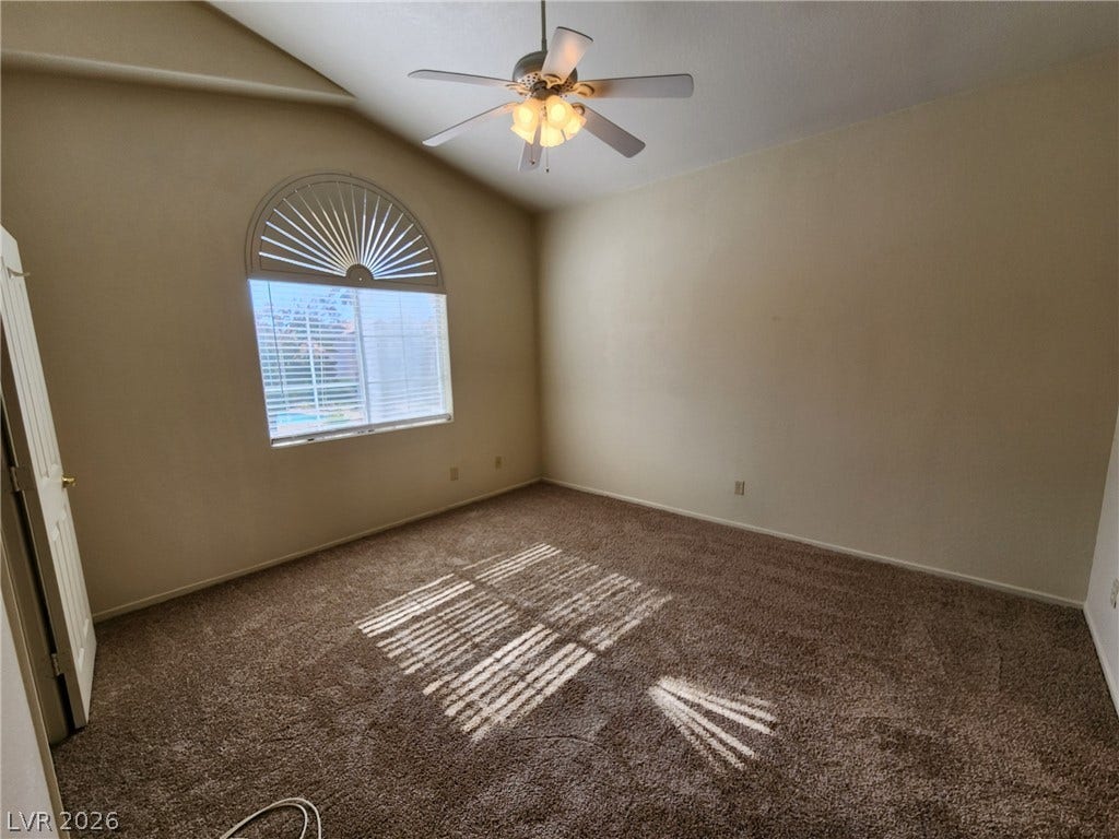 8301 Boseck Drive, #237, Las Vegas, NV 89145 Vaulted ceilings and arched window geometry elevate this carpeted bedroom space.