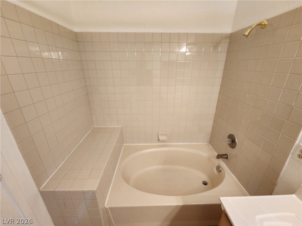 8301 Boseck Drive, #237, Las Vegas, NV 89145 Tiled walls surround a deep soaking tub featuring a built-in ledge.