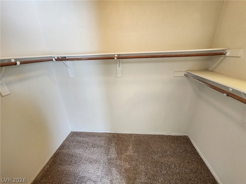 8301 Boseck Drive, #237, Las Vegas, NV 89145 A spacious walk-in closet features plush carpeting alongside wrap-around shelving and hanging rods.
