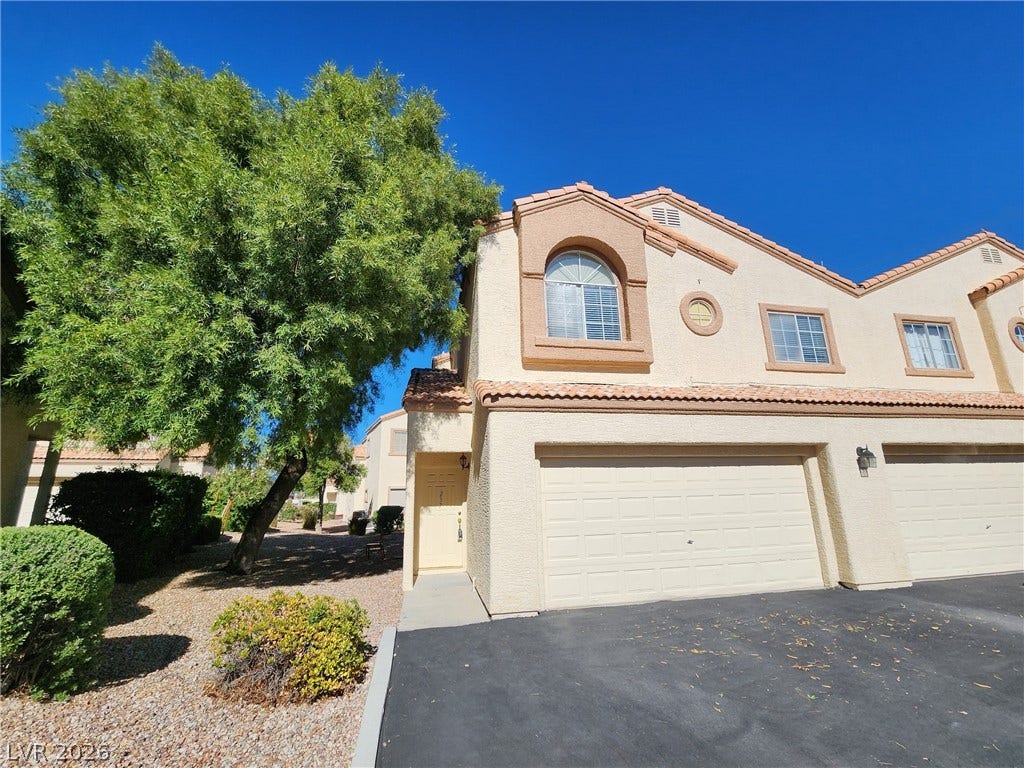 8301 Boseck Drive, #237, Las Vegas, NV 89145 Mediterranean-inspired stucco exterior features tile roofing and integrated garage access.