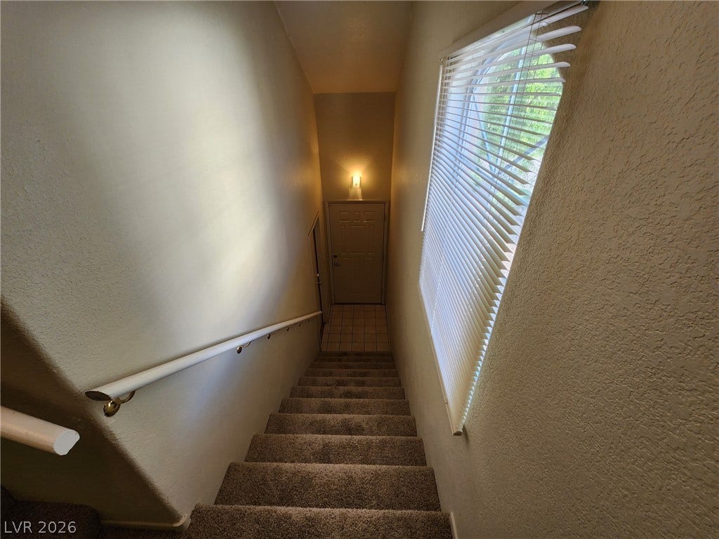 8301 Boseck Drive, #237, Las Vegas, NV 89145 Carpeted stairs lead down to a tiled entryway with a large side window.