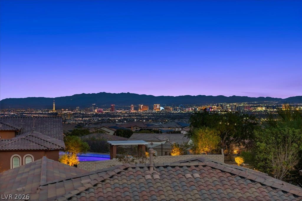 286 Besame Court, Las Vegas, NV 89138 Glimmering city lights and mountain ridges create a captivating backdrop against the twilight sky.