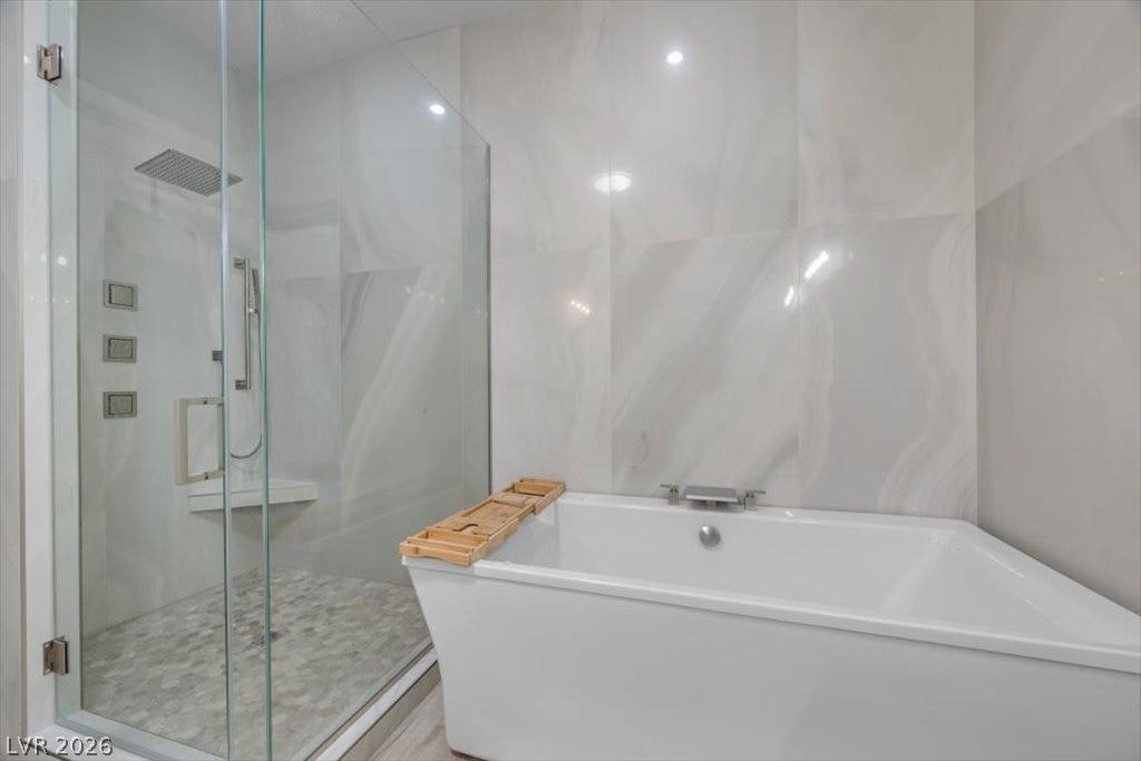 286 Besame Court, Las Vegas, NV 89138 Floor-to-ceiling tiling surrounds a deep soaking tub and a glass-enclosed walk-in shower.