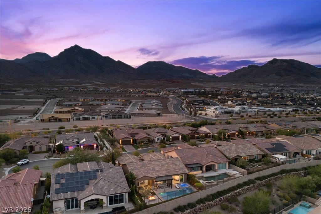 286 Besame Court, Las Vegas, NV 89138 Dramatic mountain vistas rise above the peaceful neighborhood rooftops under a twilight sky.