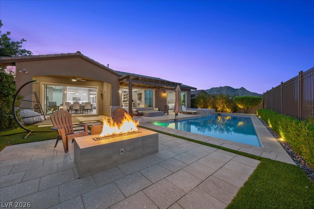 286 Besame Court, Las Vegas, NV 89138 An inviting backyard oasis features a modern pool, fire pit, and beautiful mountain views.