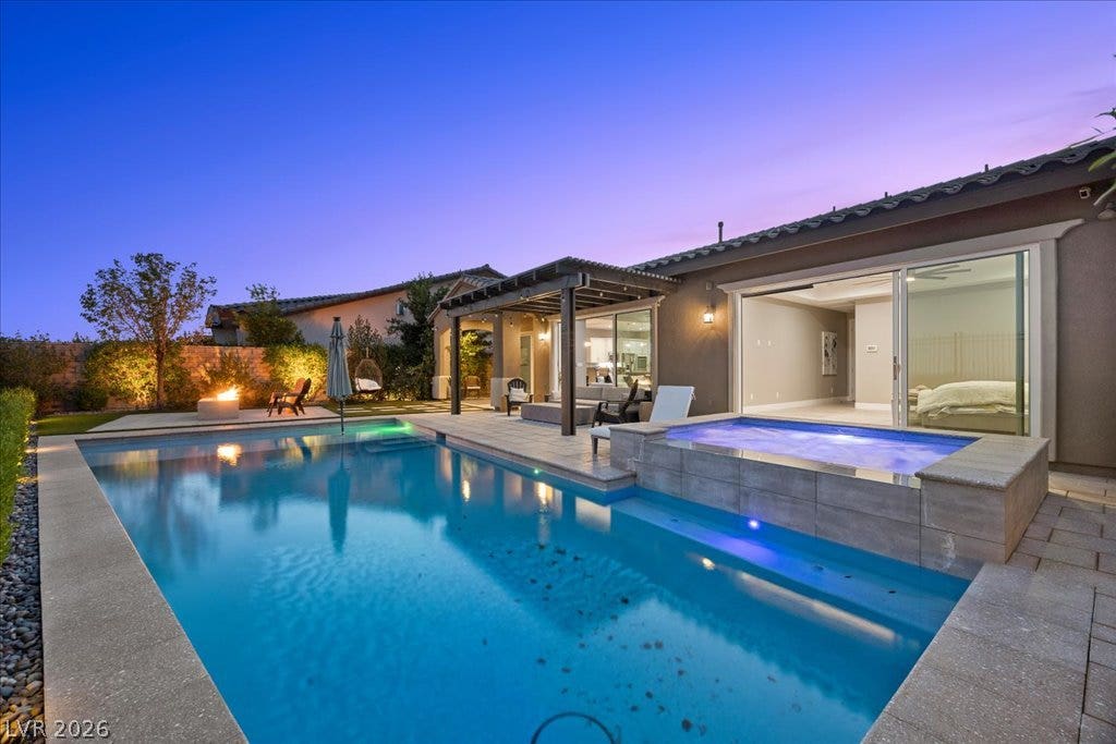 286 Besame Court, Las Vegas, NV 89138 A sparkling swimming pool and elevated spa anchor this pristine backyard oasis under evening skies.