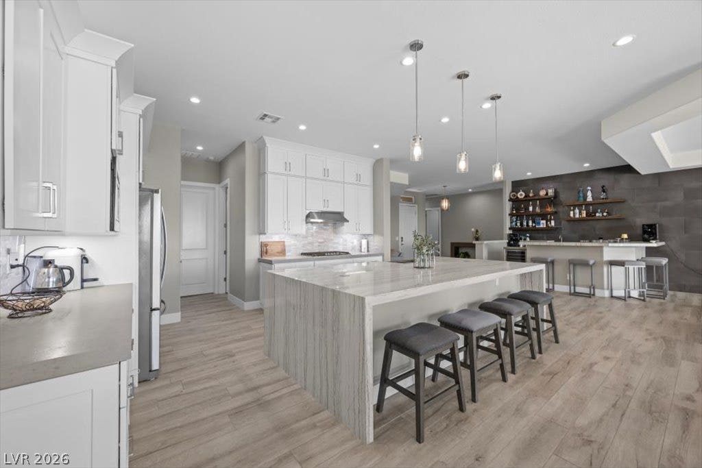 286 Besame Court, Las Vegas, NV 89138 Recessed lighting and warm wood-look flooring enhance this modern open culinary space.