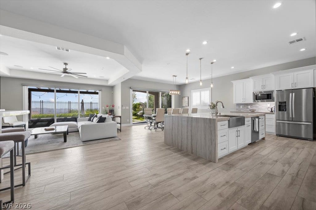 286 Besame Court, Las Vegas, NV 89138 Gleaming wood-look floors unite a spacious open layout kitchen and living area.