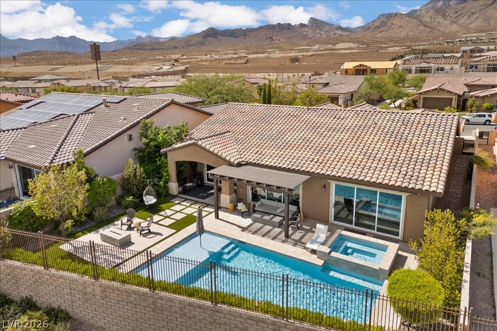 286 Besame Court, Las Vegas, NV 89138 Dramatic mountain vistas frame the tile-roofed residence and its backyard pool.