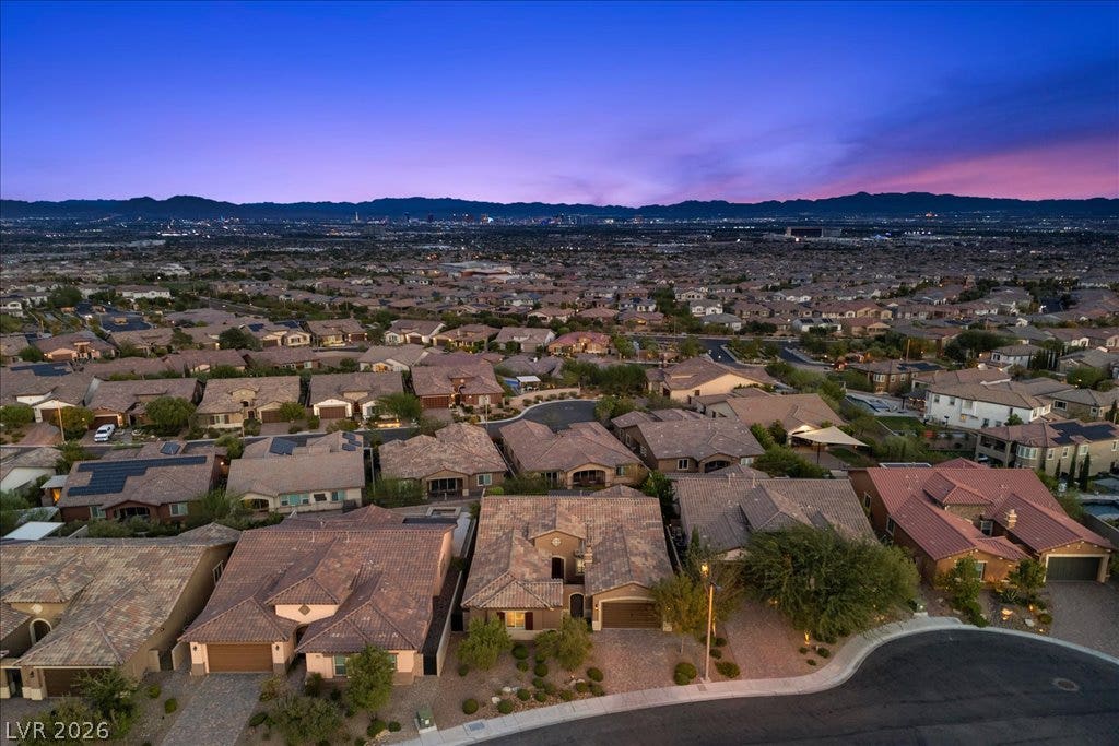 286 Besame Court, Las Vegas, NV 89138 Distant mountains frame a sprawling neighborhood under a vibrant twilight sky.