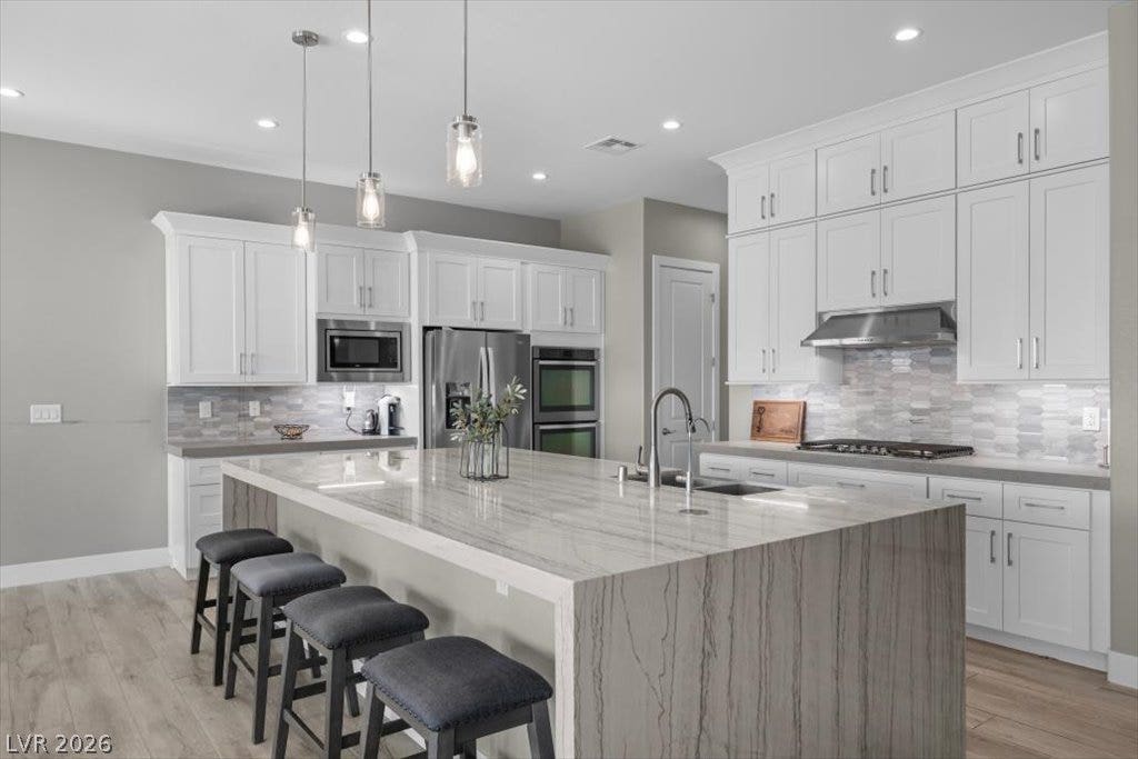 286 Besame Court, Las Vegas, NV 89138 Clean lines and a waterfall-edge stone island anchor this modern open-concept culinary space.