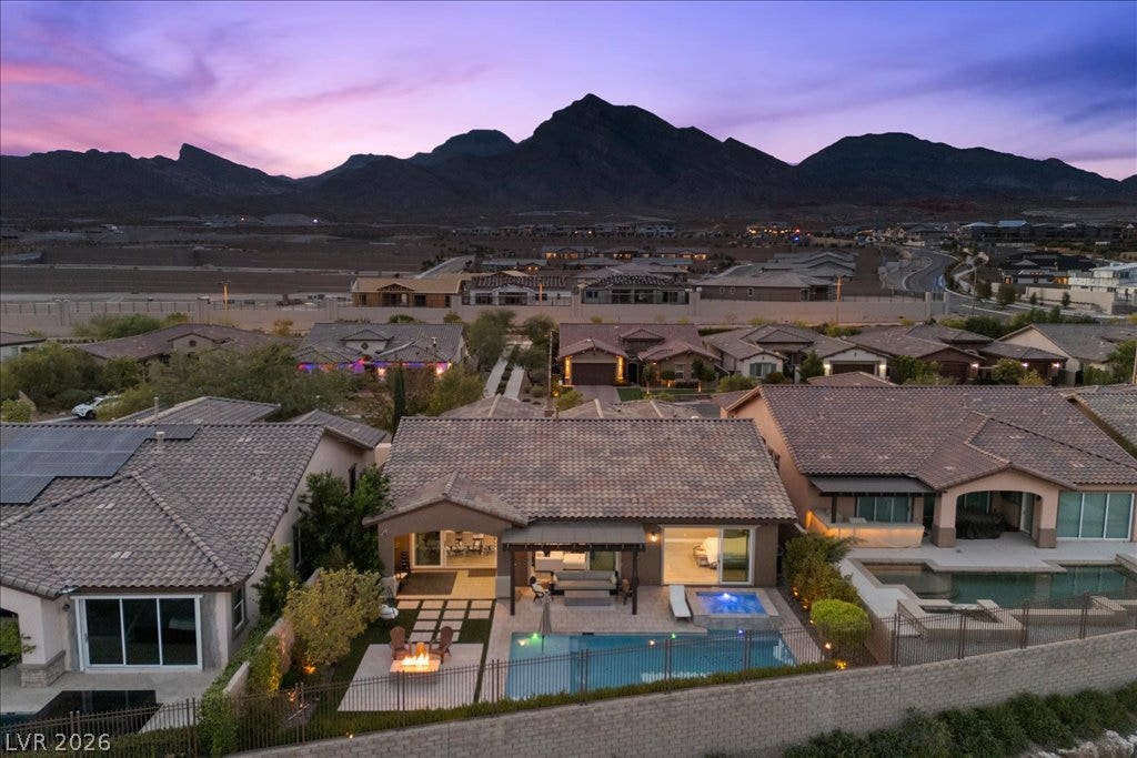 286 Besame Court, Las Vegas, NV 89138 Dramatic mountain backdrops frame this private backyard oasis under vibrant desert twilight skies.