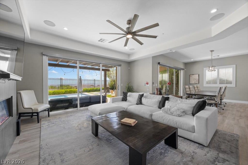 286 Besame Court, Las Vegas, NV 89138 Recessed lighting and a tray ceiling crown this open living area with sliding glass doors.