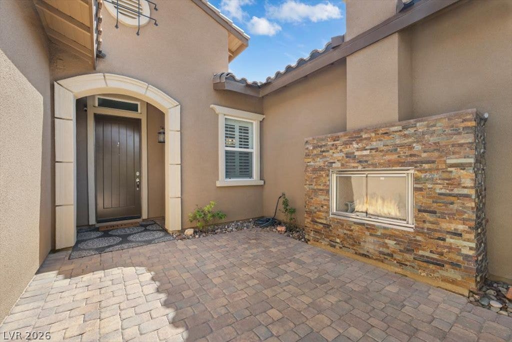 286 Besame Court, Las Vegas, NV 89138 An inviting stone fireplace warms this private brick paver courtyard entry.