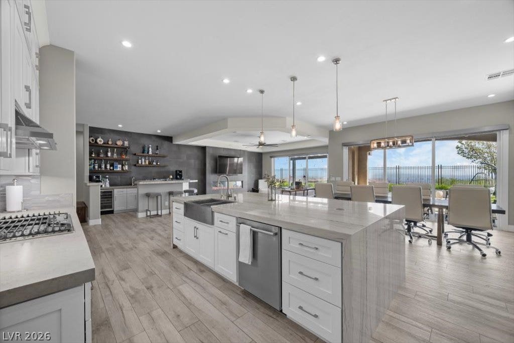 286 Besame Court, Las Vegas, NV 89138 Gleaming stone countertops and wood-look flooring anchor this spacious, light-filled open kitchen.