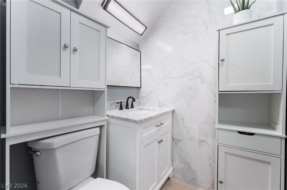 2515 Donna Street, #C, North Las Vegas, NV 89030 Elegant stone countertops and sleek cabinetry maximize storage in this modern bathroom.