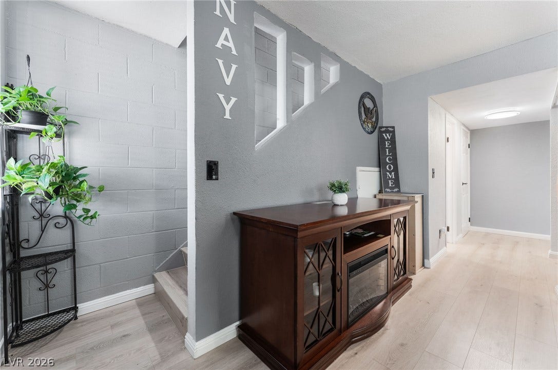 2515 Donna Street, #C, North Las Vegas, NV 89030 A modern hallway features textured block walls and light wood-tone flooring leading to adjacent spaces.