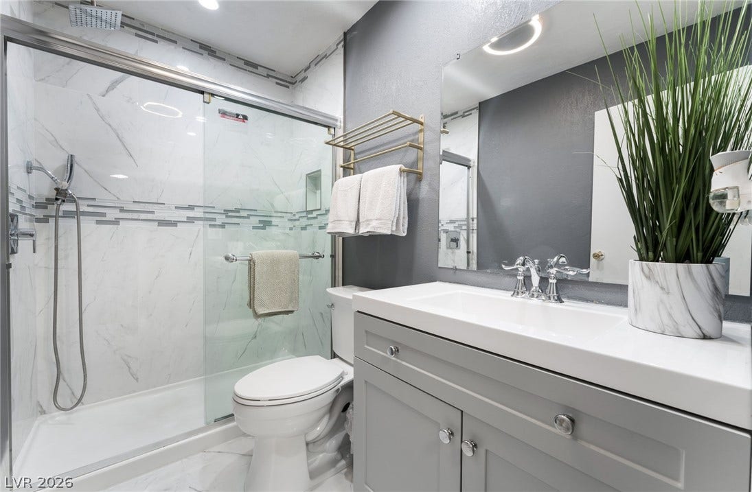 2515 Donna Street, #C, North Las Vegas, NV 89030 Modern stone counters and a sleek glass-enclosed shower elevate this updated washroom.