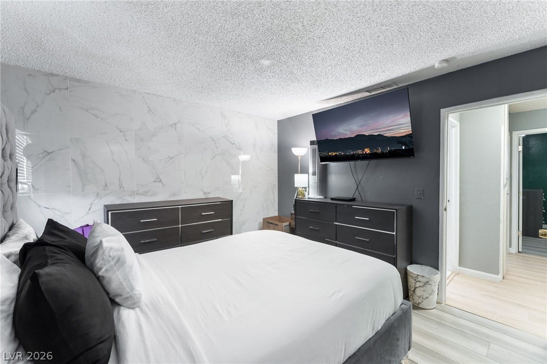 2515 Donna Street, #C, North Las Vegas, NV 89030 A stylish accent wall and light-toned flooring define this modern primary bedroom retreat.