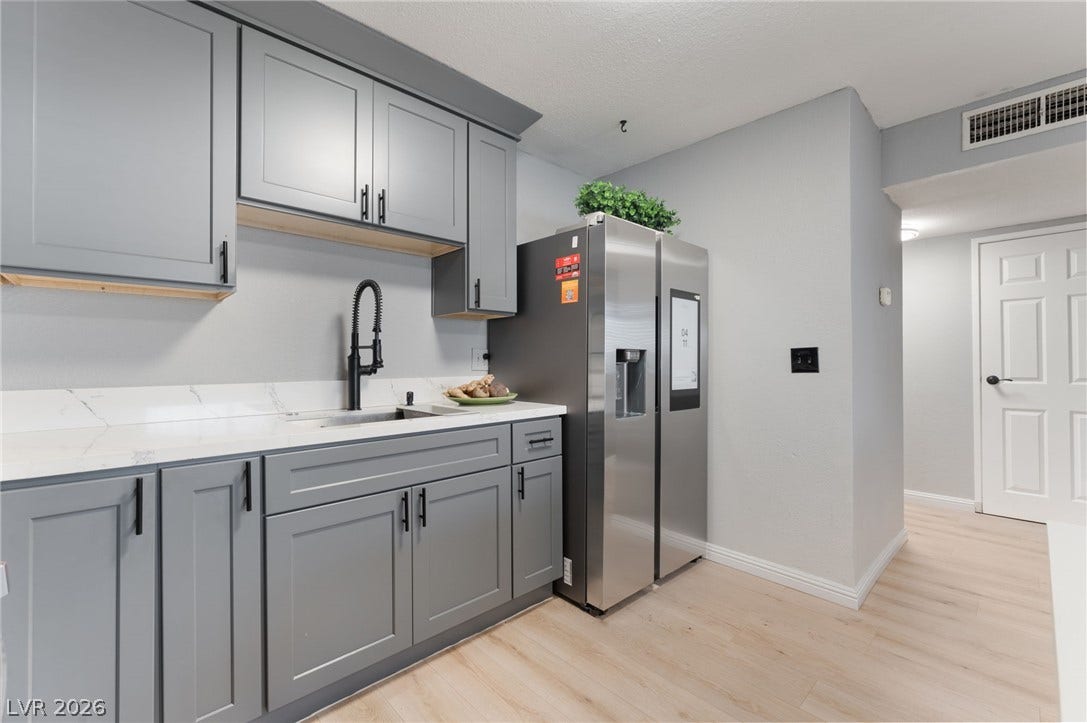 2515 Donna Street, #C, North Las Vegas, NV 89030 Modern cabinetry and stone counters line this updated kitchen space with light wood flooring.