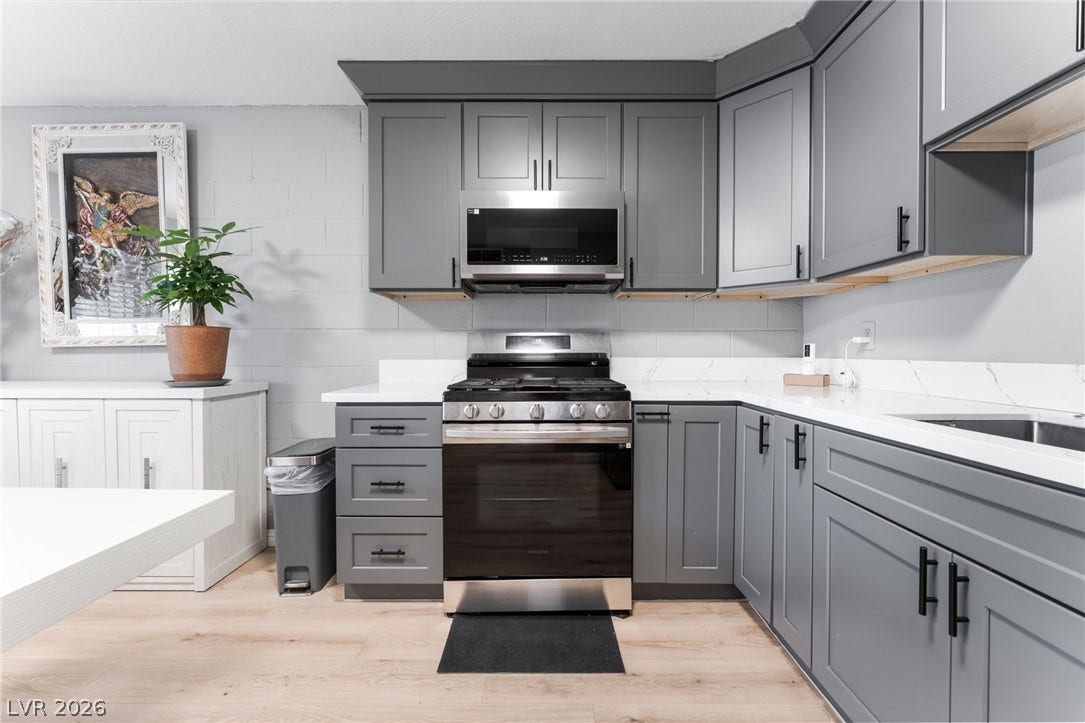 2515 Donna Street, #C, North Las Vegas, NV 89030 Modern cabinetry and stone counters create a sleek workspace on light wood-style flooring.