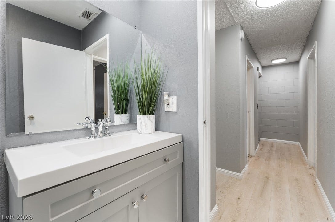 2515 Donna Street, #C, North Las Vegas, NV 89030 An updated vanity sink area transitions seamlessly into a hallway with light wood-style flooring.
