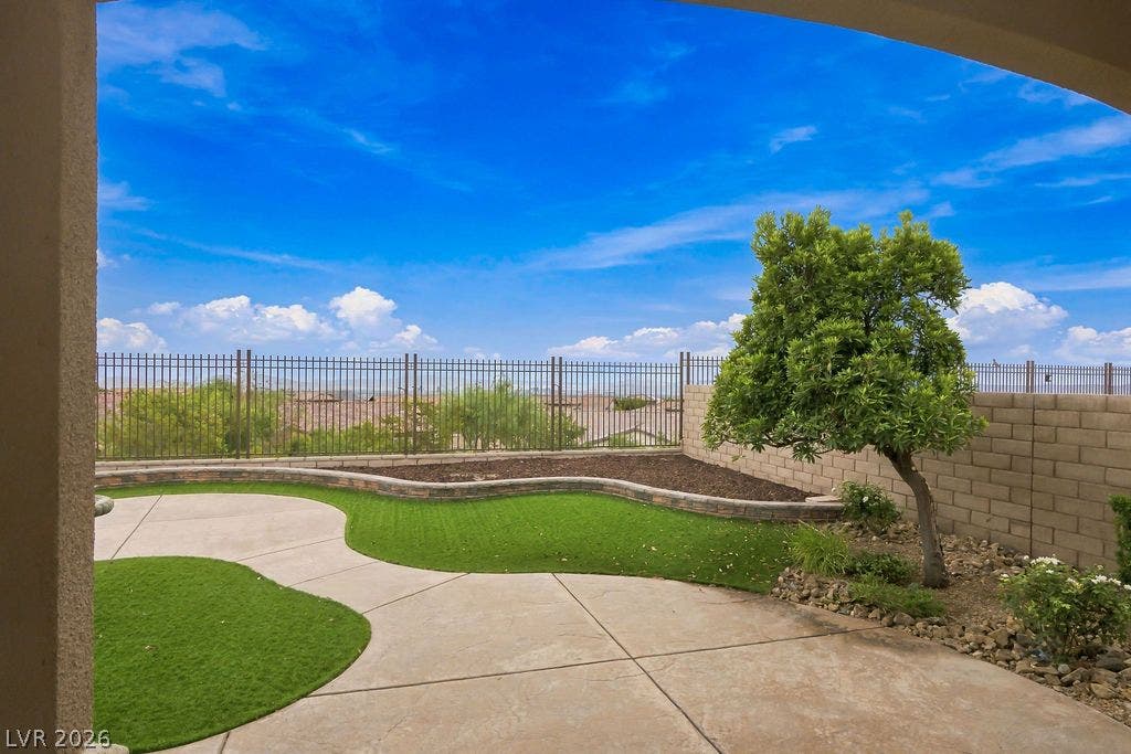 286 Lindura Court, Las Vegas, NV 89138 An inviting concrete patio overlooks a manicured backyard with a scenic distant neighborhood view.