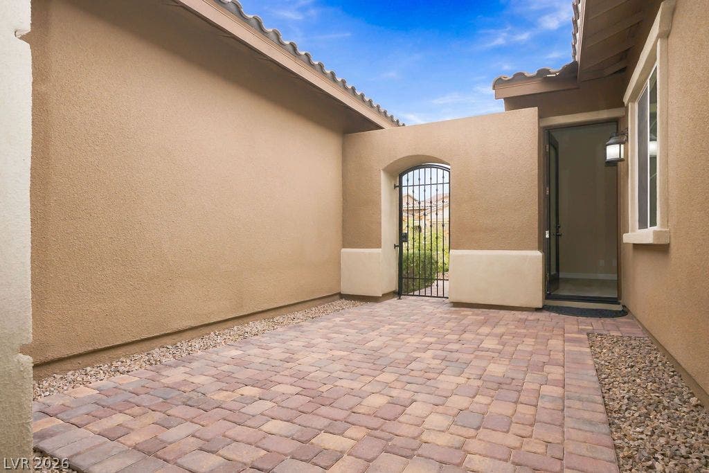 286 Lindura Court, Las Vegas, NV 89138 An inviting gated entry courtyard features durable paver flooring and stucco walls under open skies.