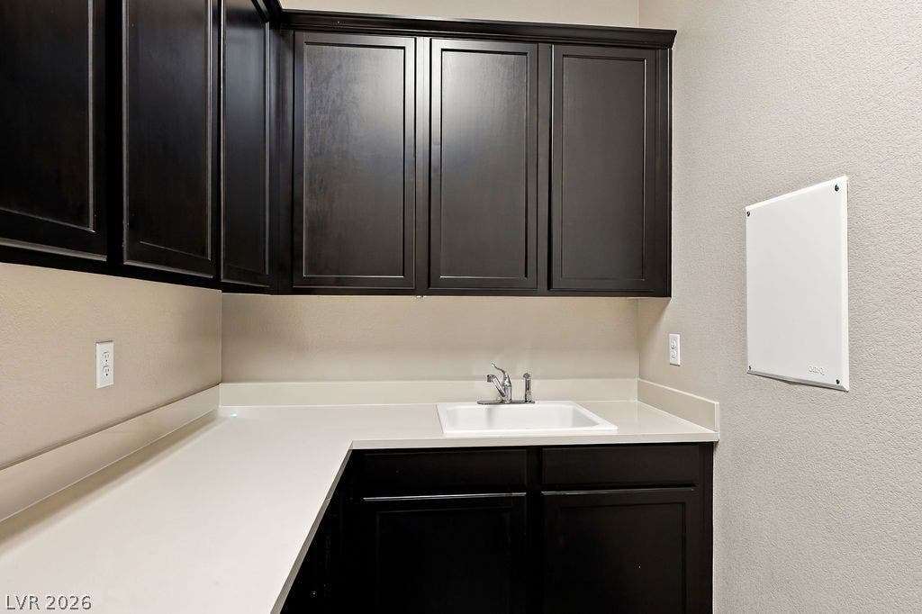 286 Lindura Court, Las Vegas, NV 89138 Rich dark cabinetry provides ample storage above the clean utility sink and solid-surface counters.