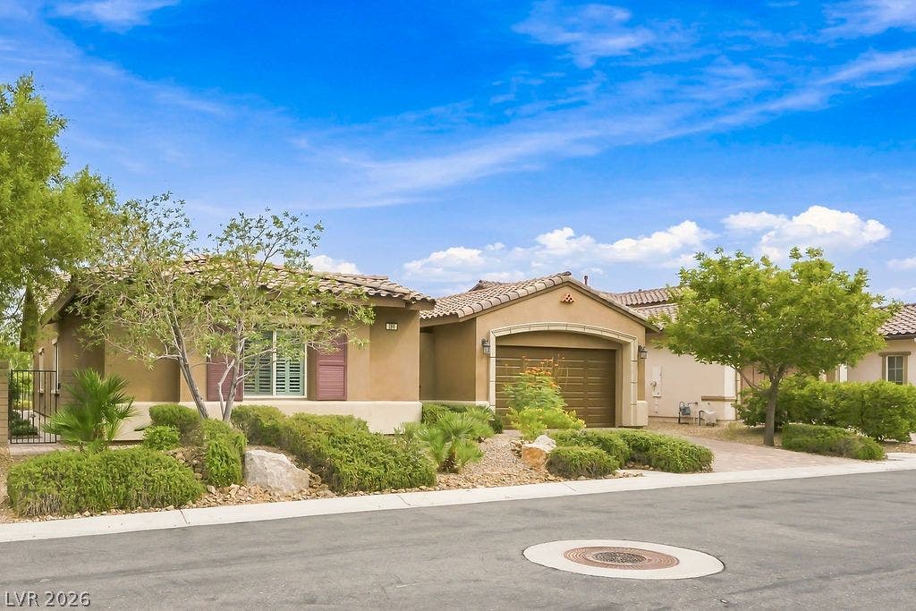 286 Lindura Court, Las Vegas, NV 89138 Manicured desert landscaping frames a stucco exterior featuring tile roofing.