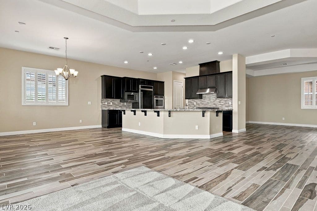 286 Lindura Court, Las Vegas, NV 89138 Gleaming wood-look tile floors sweep through a bright, open-concept kitchen and living area.