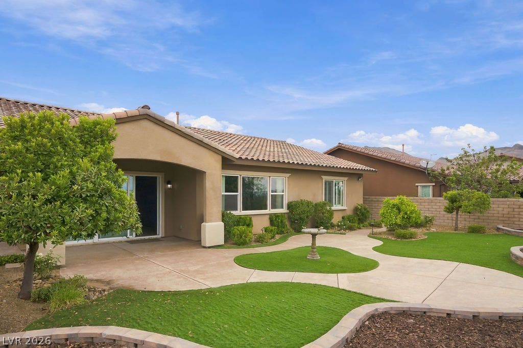 286 Lindura Court, Las Vegas, NV 89138 Sinuous concrete pathways meander through a landscaped yard bordered by masonry walls.