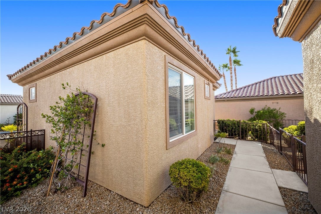 2432 Anderson Park Drive, Henderson, NV 89044 Concrete walkways trace the stucco exterior beneath classic tile roof lines.