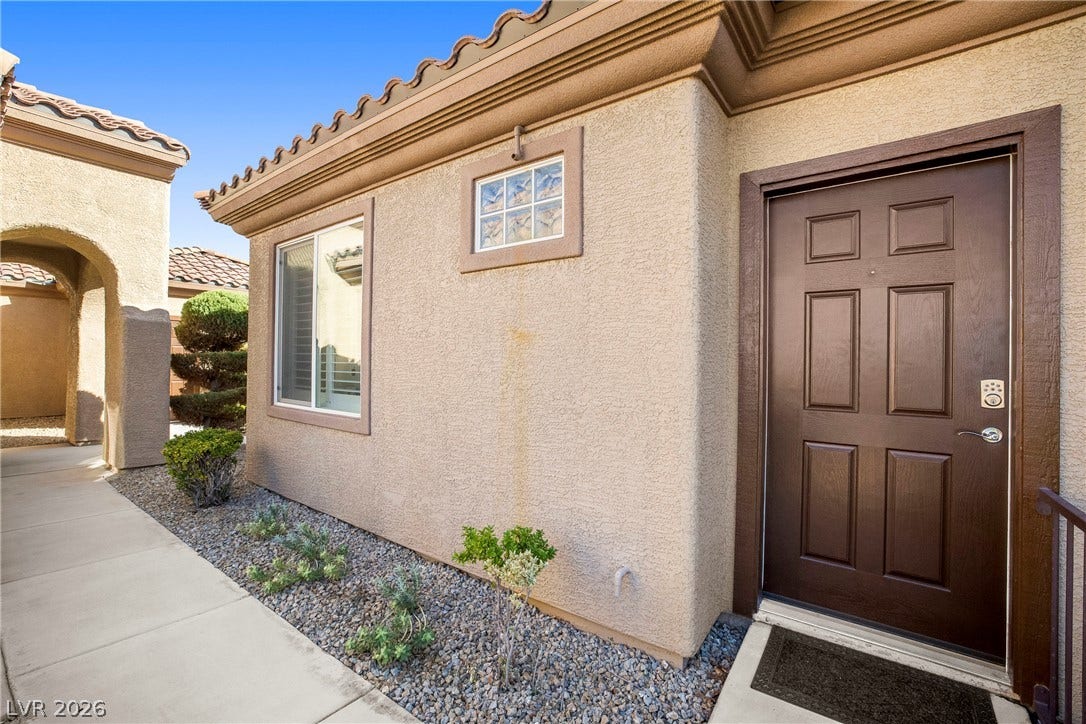 2432 Anderson Park Drive, Henderson, NV 89044 An inviting stucco exterior presents a solid front door bordered by clean concrete walkways.