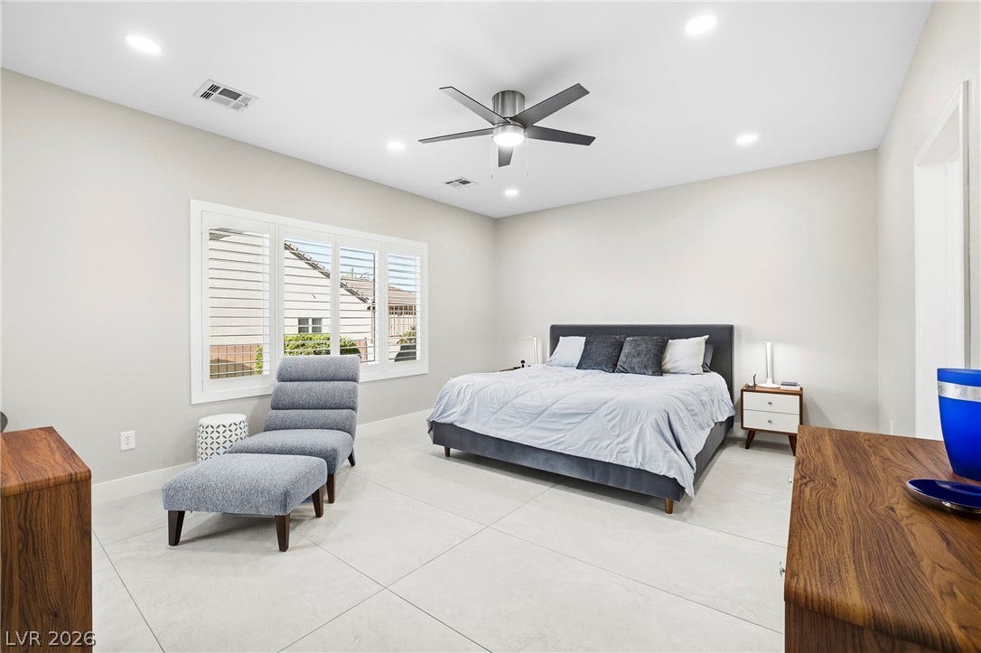 2432 Anderson Park Drive, Henderson, NV 89044 Gleaming tile floors and recessed lighting enhance this airy bedroom with custom window shutters.
