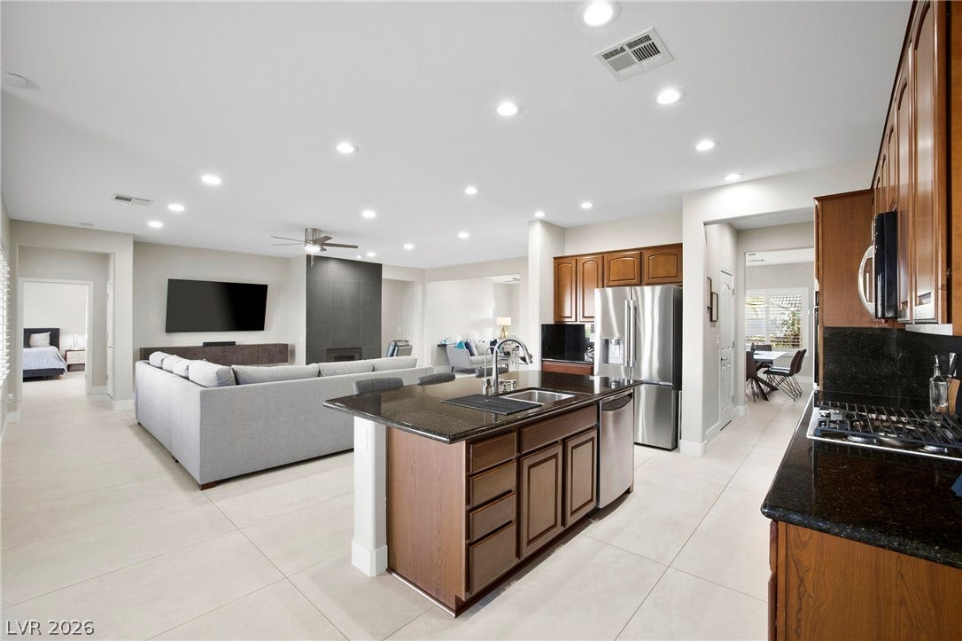 2432 Anderson Park Drive, Henderson, NV 89044 Gleaming stone countertops and warm wood cabinetry define this expansive culinary space.