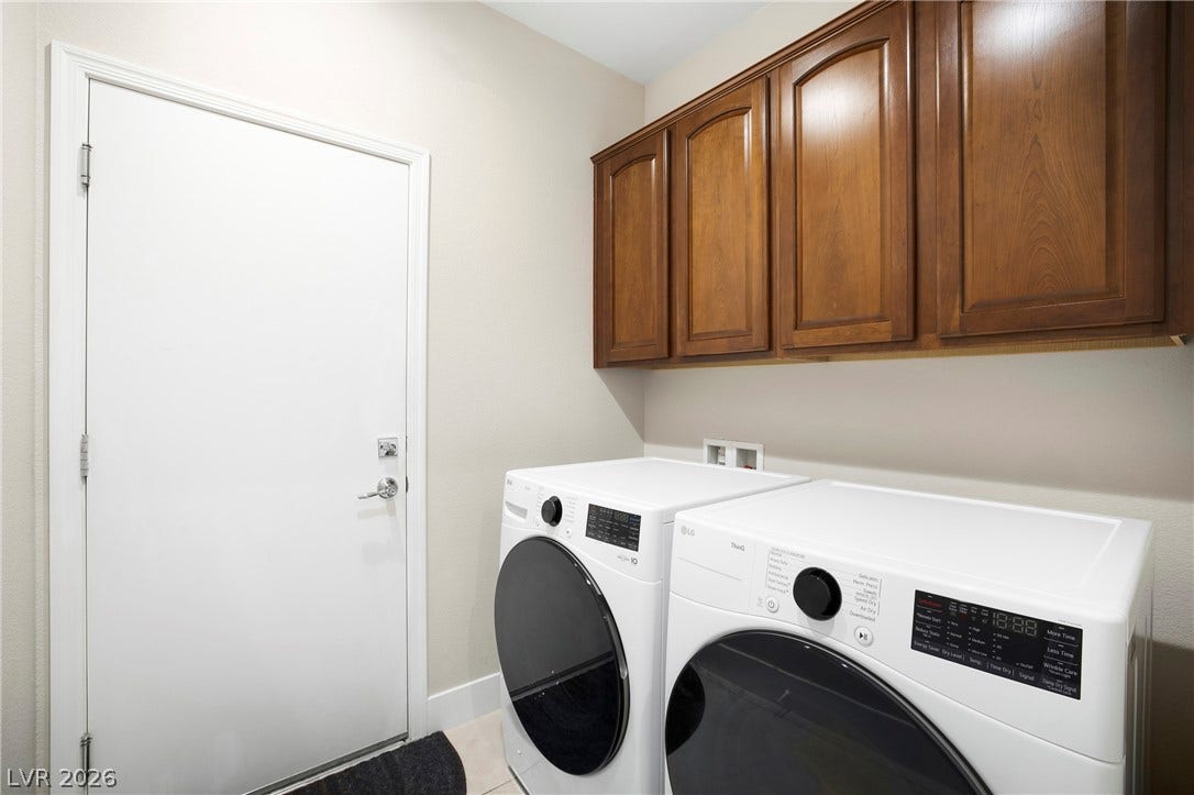 2432 Anderson Park Drive, Henderson, NV 89044 Rich wood cabinetry provides overhead storage options above the laundry setup.