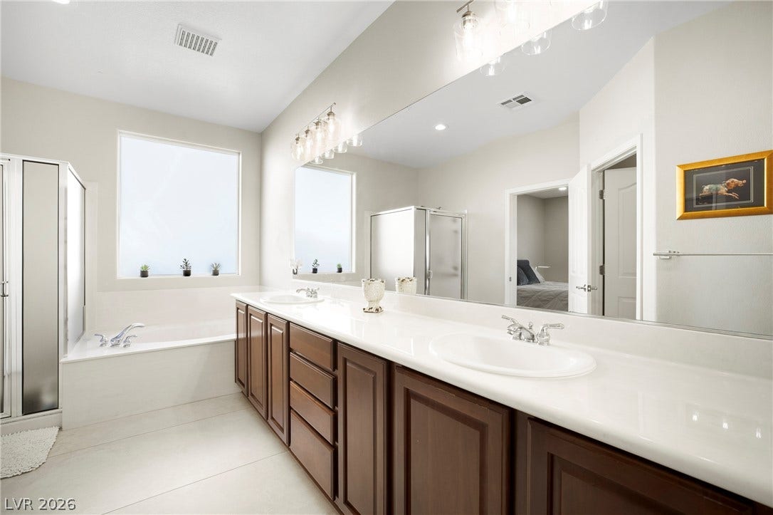 2432 Anderson Park Drive, Henderson, NV 89044 An expansive double vanity and a built-in soaking tub anchor this spacious bathroom layout.