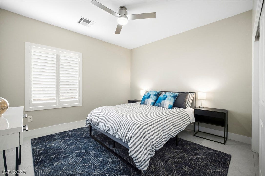 2432 Anderson Park Drive, Henderson, NV 89044 Crisp plantation shutters and tile flooring enhance this serene secondary bedroom.
