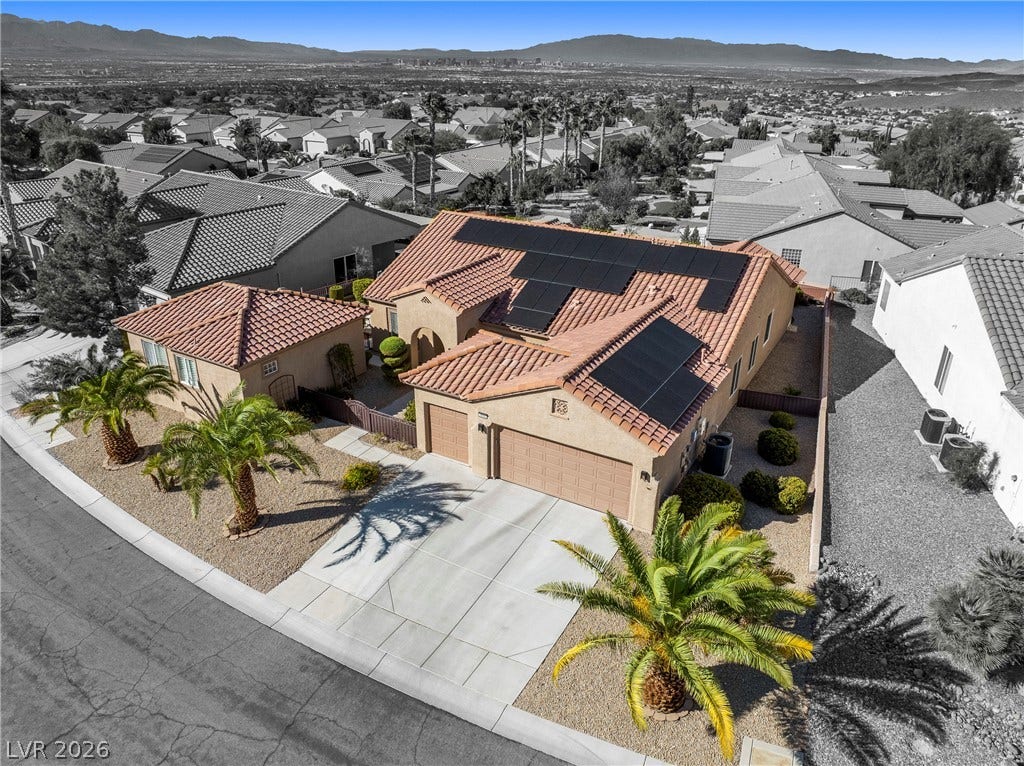 2432 Anderson Park Drive, Henderson, NV 89044 Solar panels line the tile roof of this desert home situated on a manicured lot.