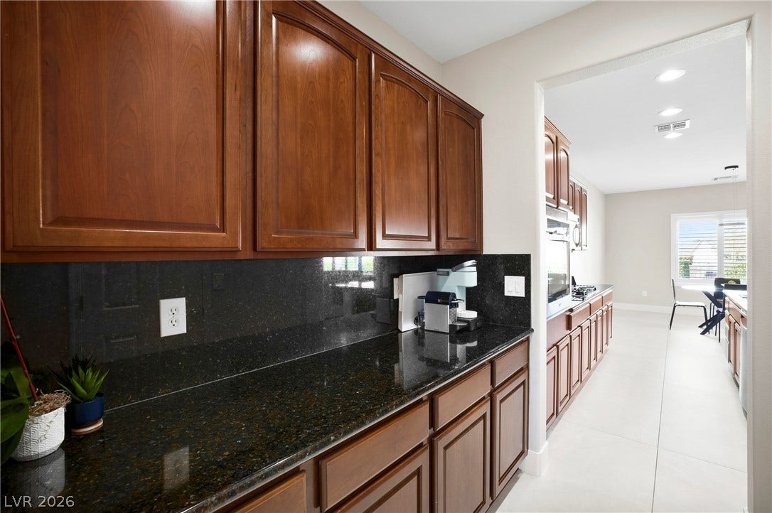 2432 Anderson Park Drive, Henderson, NV 89044 Rich wood cabinetry paired with dark granite countertops defines this highly functional butler pantry area.