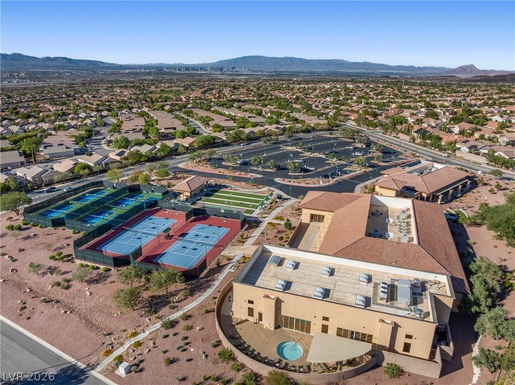 2432 Anderson Park Drive, Henderson, NV 89044 An aerial perspective showcases a comprehensive community center complete with tennis courts and mountain backdrops.
