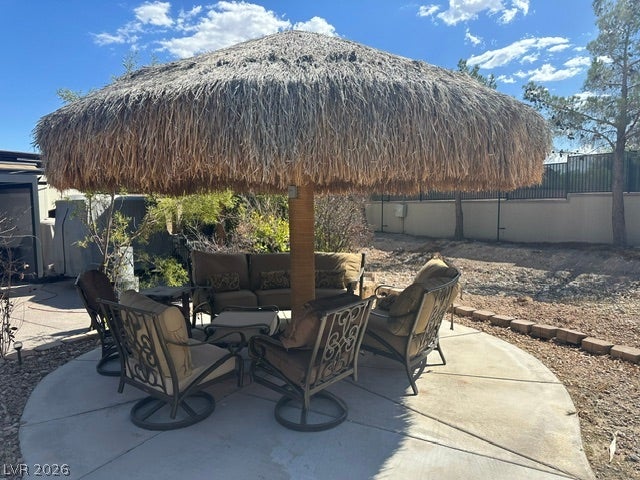8175 Arville Street, #203, Las Vegas, NV 89139 A spacious concrete patio rests beneath a large thatched palapa in the backyard.