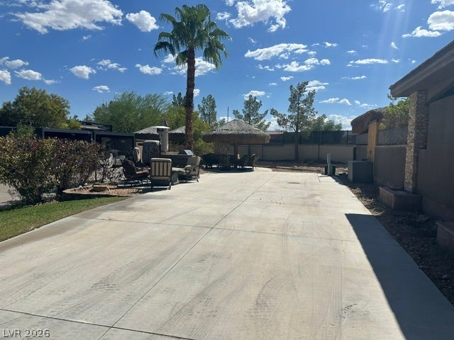 8175 Arville Street, #203, Las Vegas, NV 89139 An expansive concrete patio extends alongside the home under a blue sky.