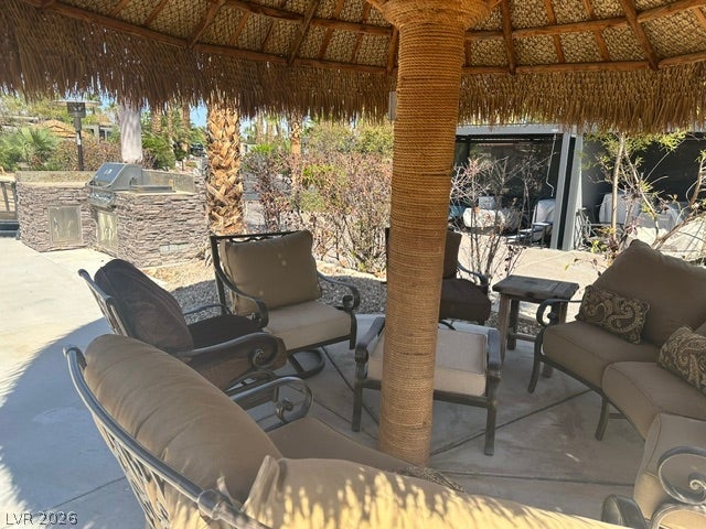 8175 Arville Street, #203, Las Vegas, NV 89139 An inviting thatched-roof structure shelters a comfortable seating area adjacent to a stone outdoor kitchen.