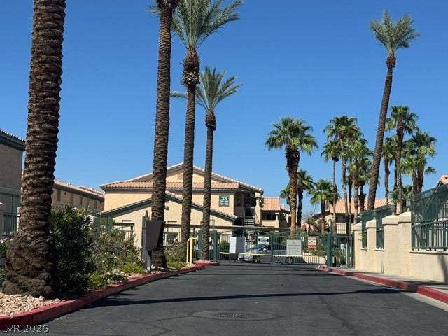 Towering palm trees frame the gated entrance to this secure residential community.