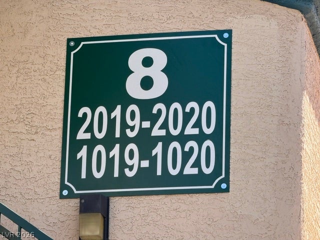 Textured stucco wall highlights the building signage and clear exterior directional markings.