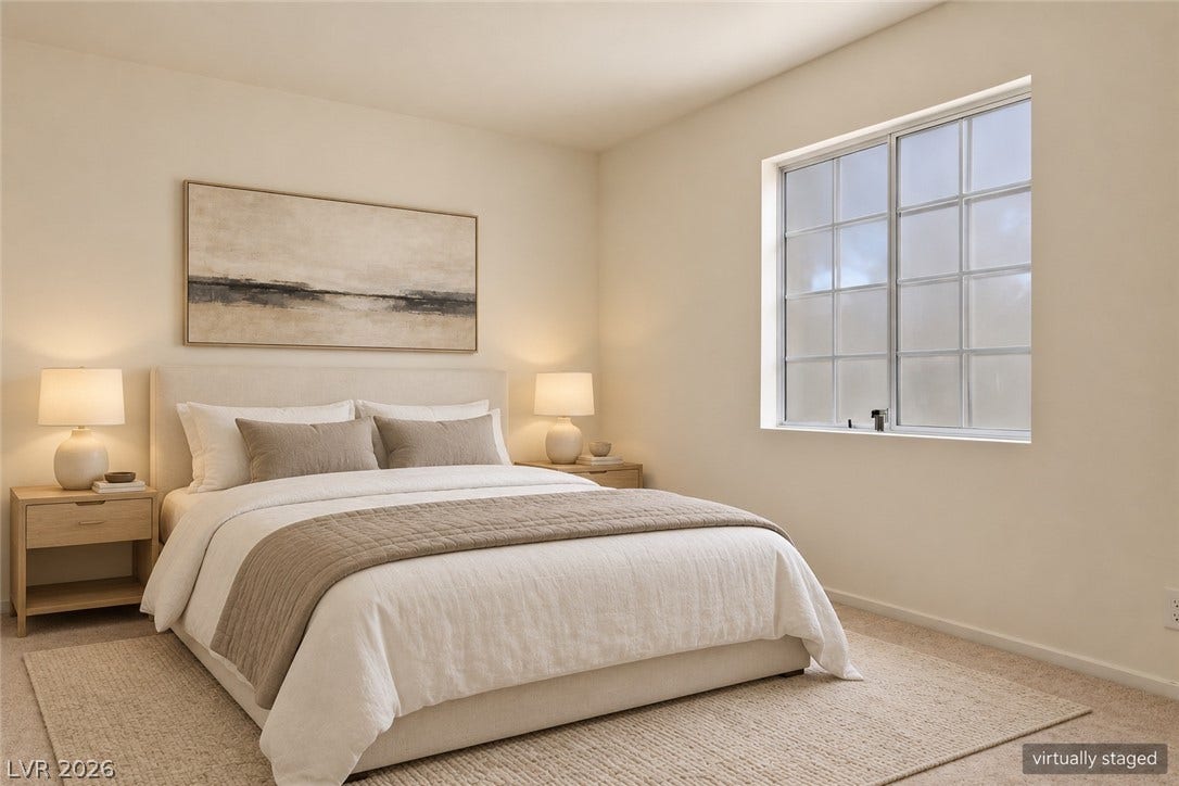 Natural light pours through a multi-pane window in this serene bedroom with plush carpeting.