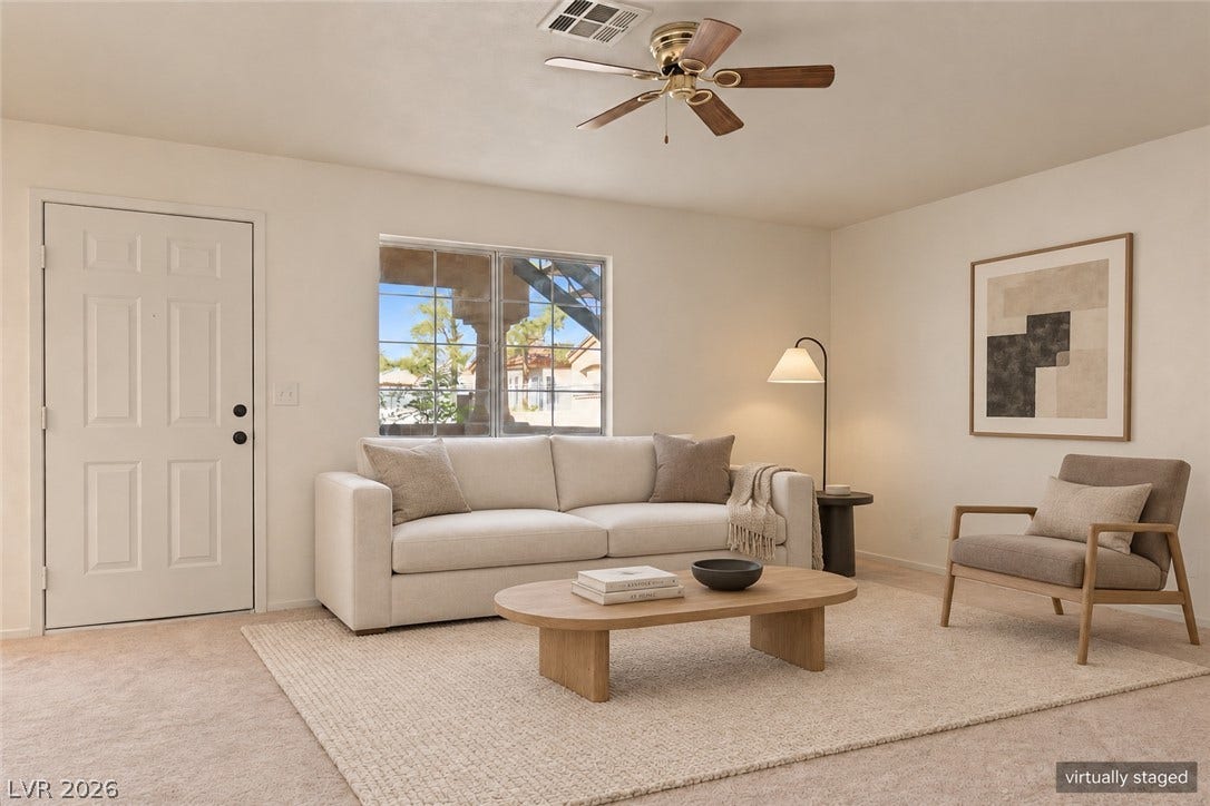 A window bathes the living area in natural light, showcasing the carpeted flooring.